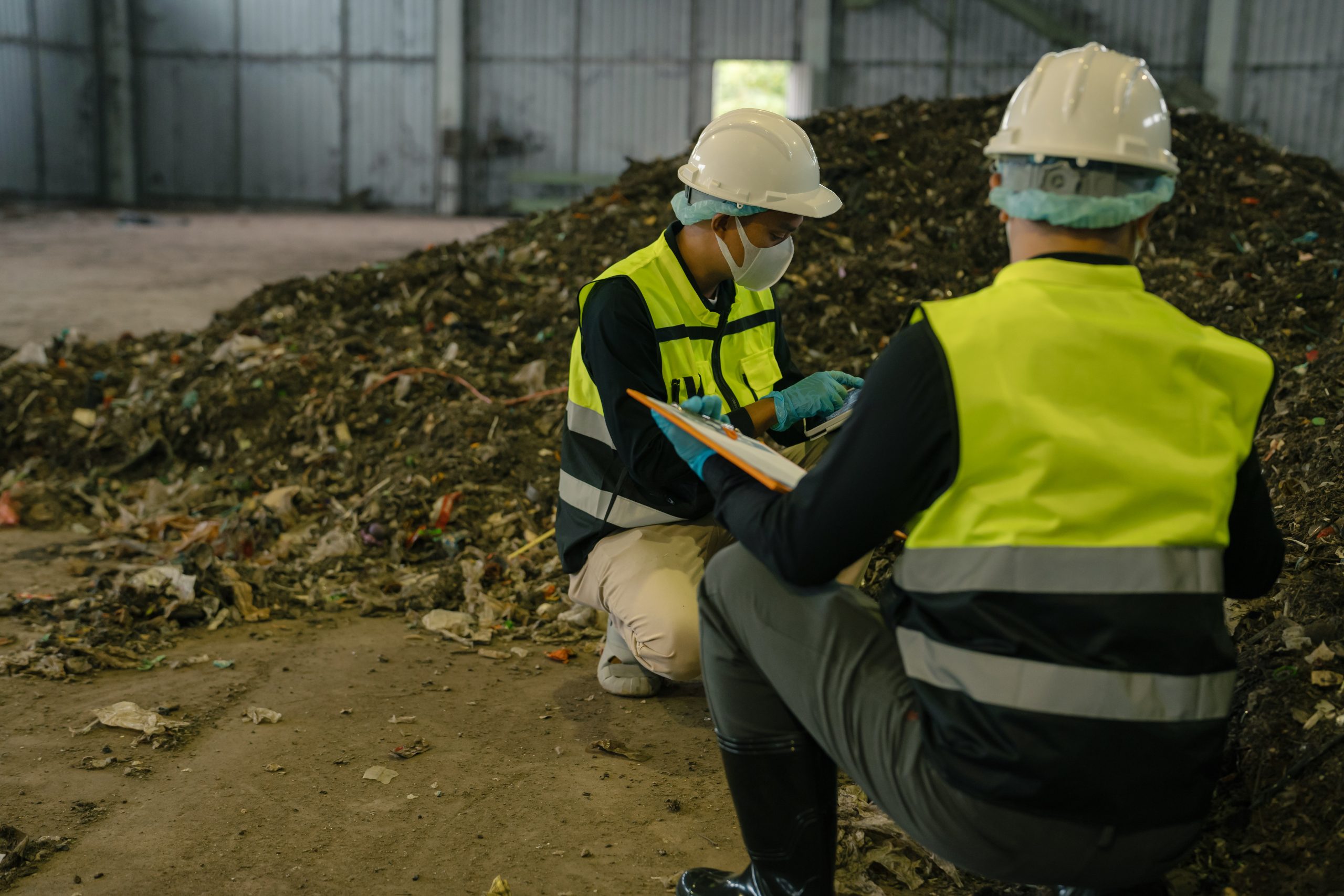 Two technicians assessing a waste pile to check odour and dust controls